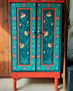 an old cabinet painted with flowers and leaves