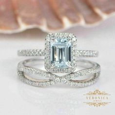 a ring with an aquamarine colored diamond surrounded by white gold and pave diamonds