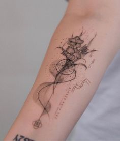 a woman's arm with a tattoo on it that has lines and flowers in the middle