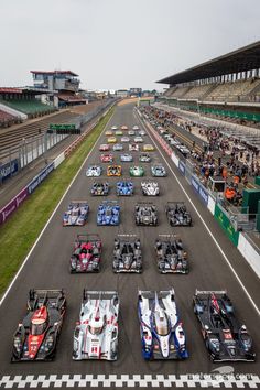 a group of cars driving down a race track