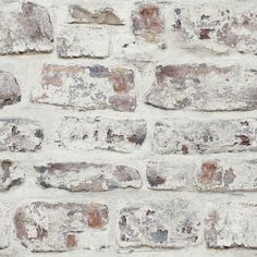 an old brick wall with white paint on it