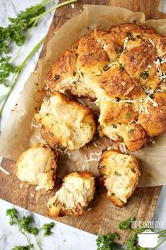 the bread is cut in half and placed on top of parchment paper with parmesan sprinkles