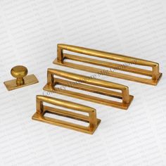 three brass drawer pulls on a white background