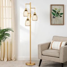 a living room with a couch, chair and lamp on the floor next to a potted plant