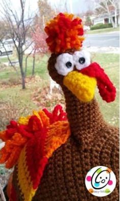 a crocheted turkey sitting in front of a window