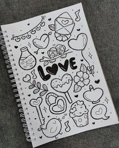 a notebook with drawings on it and the words love written in black ink, sitting on a table