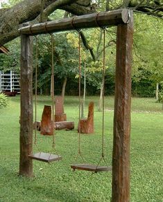 a wooden swing set in the middle of a yard