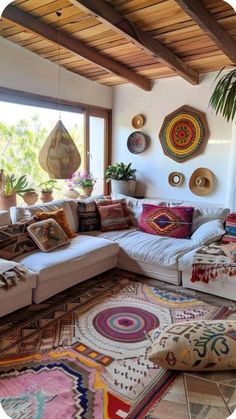 a living room filled with lots of furniture and pillows on top of a rug covered floor