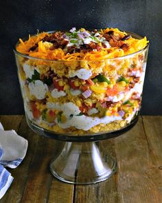 a large glass dish filled with food on top of a wooden table