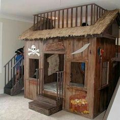 there is a pirate themed house in the living room with stairs to the second floor