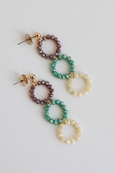 The finishing touch to all your best looks is the Melissa Teal Beaded Circle Drop Earrings! These trendy gold earrings start with a stud post back and fall to colorful beaded circles. Add these fun earrings to a floral dress + sandals to add a girly touch to your look! Gold Plated Beaded Circles Stud Post Back One Size | Length 2” Tiny Bead Earrings, Bead Wire Earrings, Trendy Gold Earrings, Simple Bead Earrings, Wooden Bead Earrings, Beaded Circle, Homemade Earrings, Beautiful Beaded Jewelry, Handmade Hoop Earrings