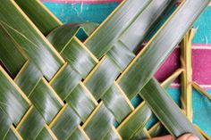 a person is cutting up some green leaves on a woven table cloth, with scissors in the foreground