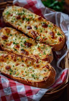 three slices of bread with cheese and parsley in a basket on a checkered table cloth