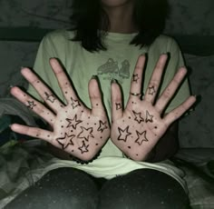 a woman with her hands covered in stars on her left and right palms up to the camera