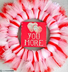 a red and white tulle wreath with the words you more written in gold on it