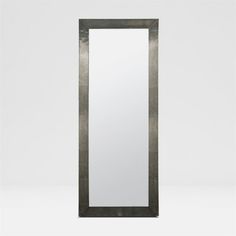 a tall mirror sitting on top of a white wall