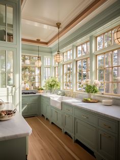 a kitchen filled with lots of green cabinets