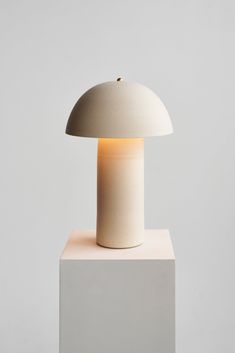 a white table lamp sitting on top of a block