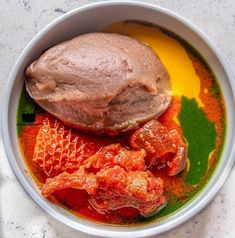 a bowl filled with meat and sauce on top of a table