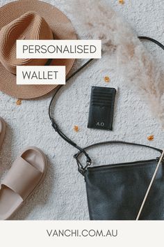 the personalised wallet is next to some shoes and a hat on top of a white carpet