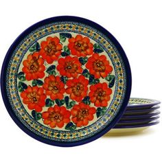 four plates with red flowers on them are stacked up in front of each other,