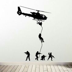 a wall decal with the silhouettes of soldiers climbing up to a helicopter