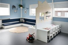 a child's room with blue walls and white furniture