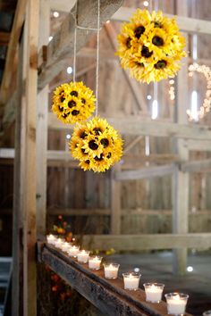 sunflowers are hanging from the ceiling with candles