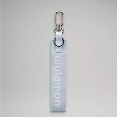 a white lanyard with the word imagine on it and a metal hook attached to it