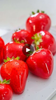 a group of strawberries sitting on top of a white plate next to each other