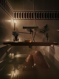 two feet in a bathtub with candles and plants