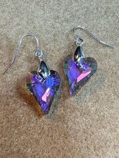 These AB finished glass heart earrings are the color of purple with silver earwires. They are lightweight and glittery. The earrings are made out of crystal with a heart shape approximately 1 inch.  Very pretty earrings that will change colors in the light. Colors are purple, blue and pink. Wire Heart, Glass Heart, Pretty Earrings, Blue And Pink, Ear Wire, Heart Earrings, Heart Shape, Suncatchers, A Heart