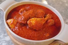 a bowl filled with meatballs and sauce on top of a table