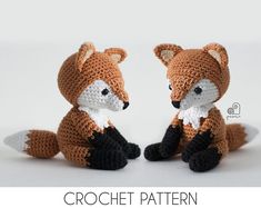 two crocheted foxes sitting next to each other