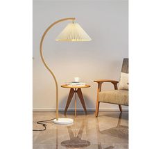 a lamp that is next to a table with a cup on it and a chair in the background