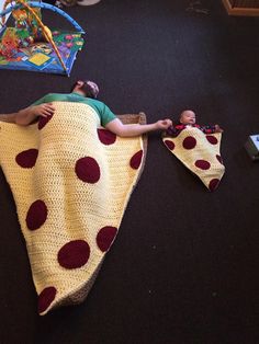 a baby laying on top of a blanket next to a cell phone