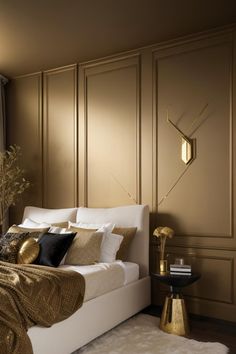 a bedroom with gold accents and white bedding