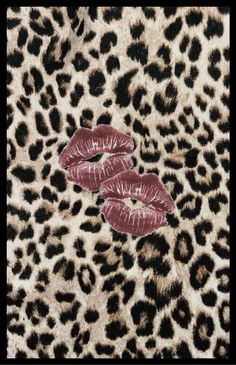 two red lipsticks laying on top of a leopard print fabric