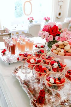 an assortment of desserts and pastries on a table with flowers in the background