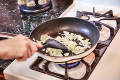 someone is frying onions in a skillet on the stove top with a spatula