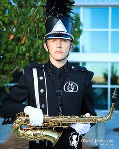 a man in uniform is holding a saxophone and wearing a feathered headdress