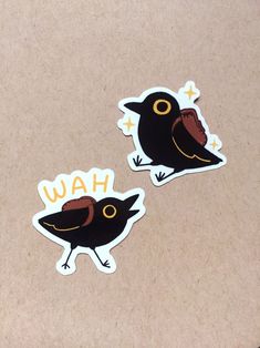 two stickers with the words wah and a black bird on it's back