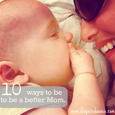 a woman holding a baby in her arms and smiling at it's face while wearing sunglasses