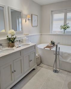 a bathroom with a tub, sink, and mirror in it's center area