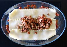 two ravioli with meat and sauces on a glass plate, ready to be eaten