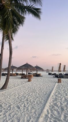 the beach is lined with umbrellas and lounge chairs