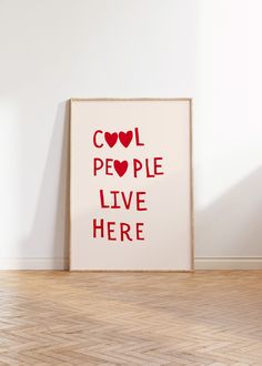 a white framed poster with the words cool people live here in red letters on it