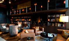 a living room filled with lots of furniture and bookshelves next to a fire place