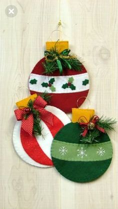 three christmas ornaments hanging on a wooden wall