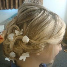 a woman's head with flowers in it and hair combs on her head